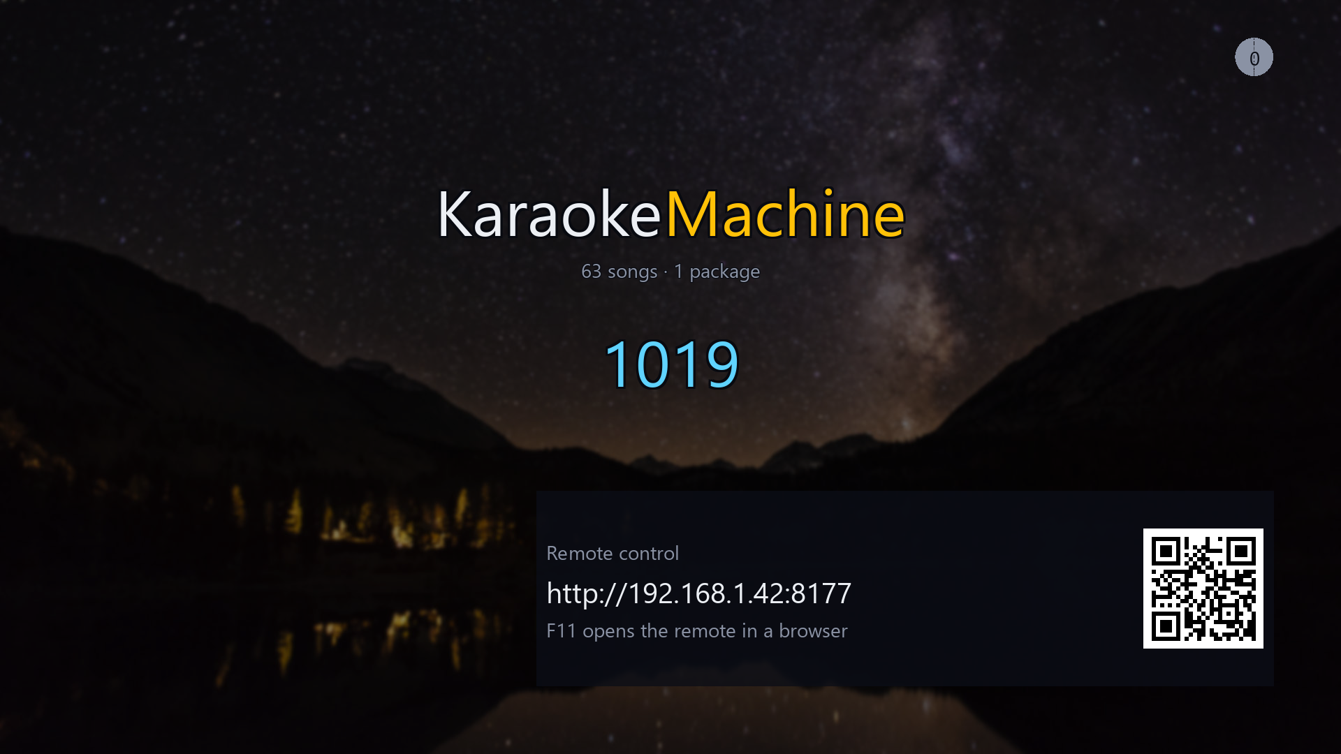 The idle screen: a partly typed song number in blue, a disc in the corner counting
                the songs waiting, and a panel giving the machine's address on the network beside a
                QR code